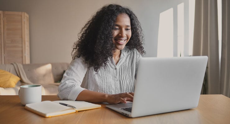 A female student uses her laptop to explore activities for a gap year after high school