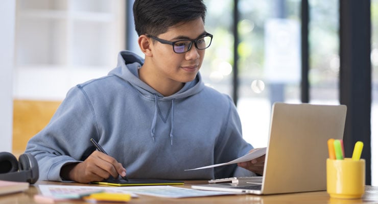  A male college student attends an online course on his laptop