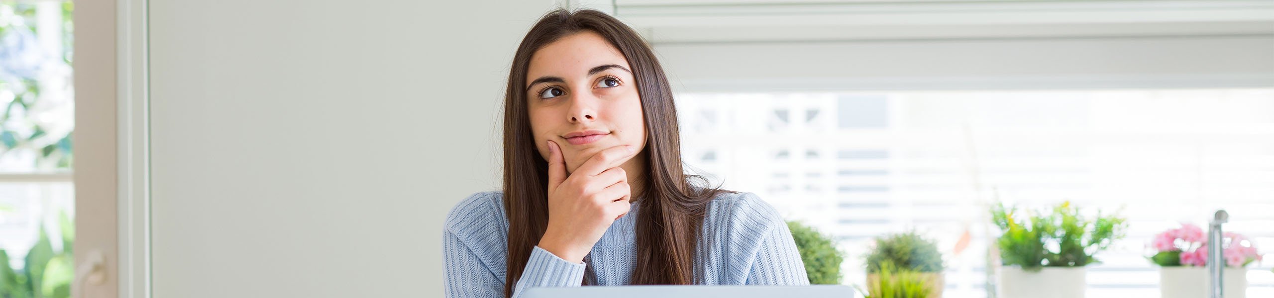 A student with her hand on her face, deep in thought.