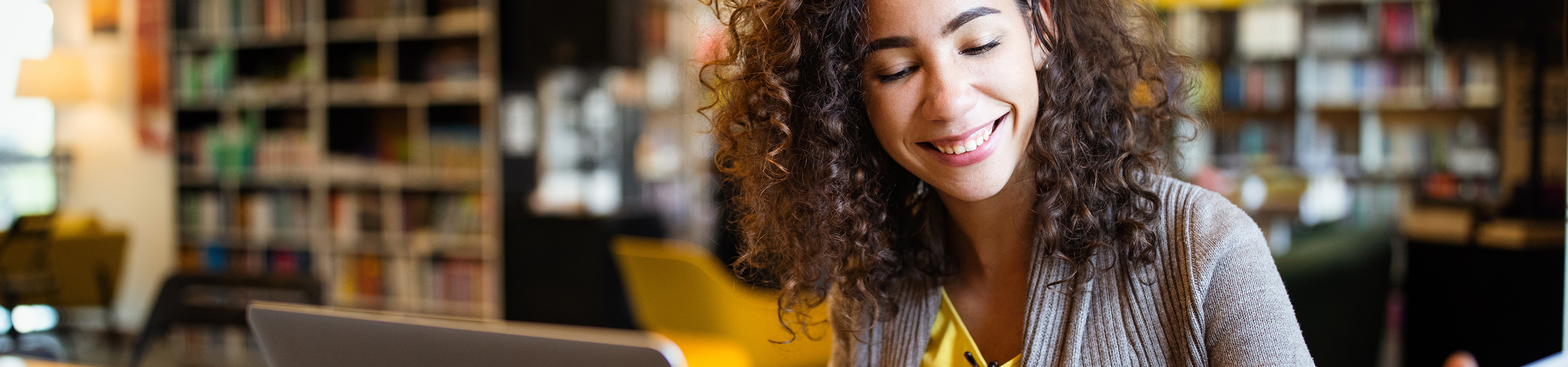 female high school student in a library studying for the PSAT / NMSQT test to become a national merit scholar.