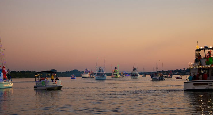 A bunch of boats on the water decorated for Christmas.