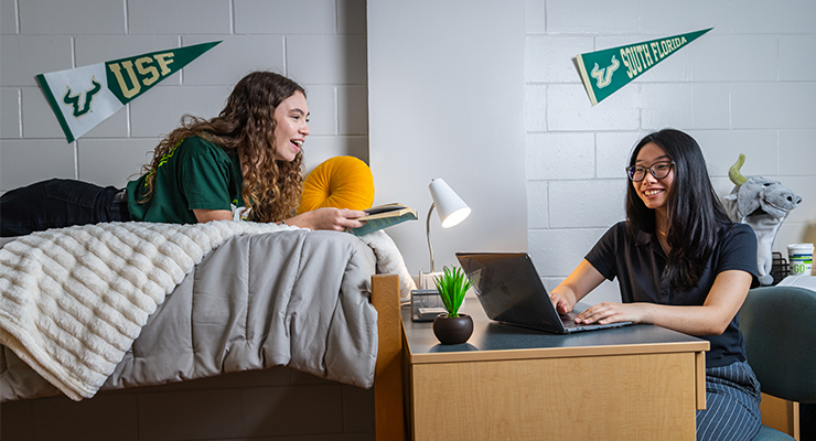 Two students hanging out in their dorm room.