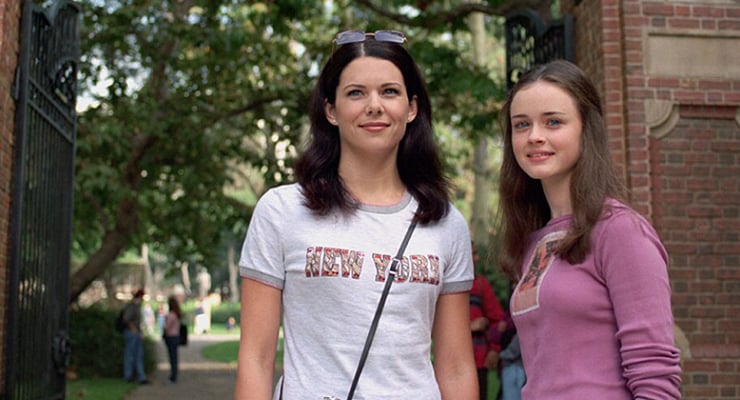 Two women, Lorelai and Rory Gilmore, standing in front of a brick structure.
