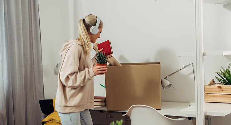 A student taking out a plant and a book for her dorm room.
