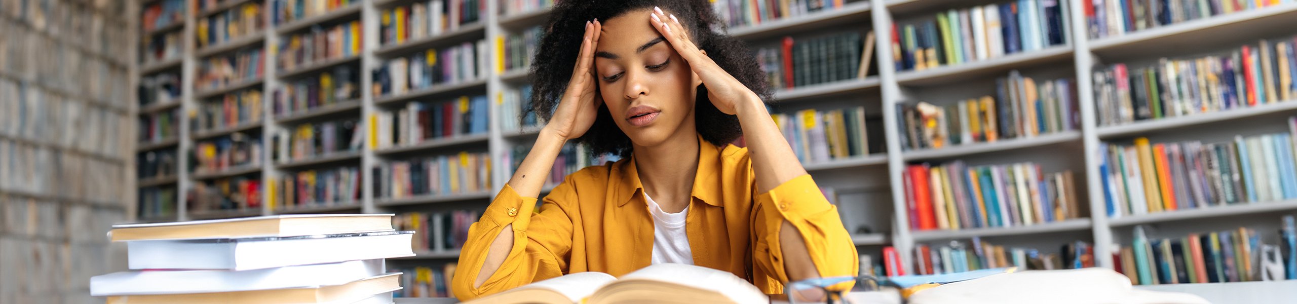 A student reading a book in a library.