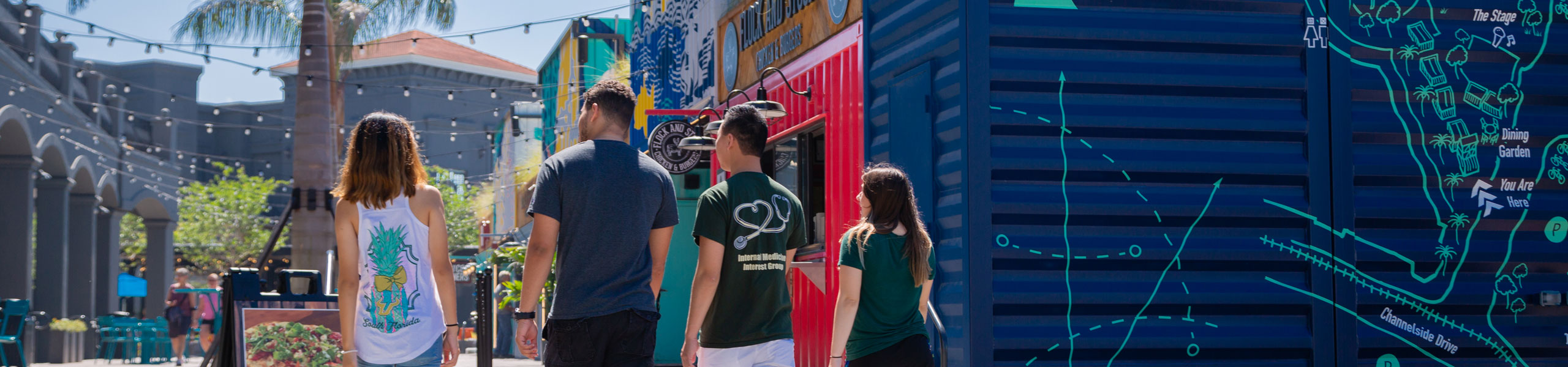 A group of students entering Tampa's Sparkman Wharf, a popular spot for restaurants, shops and street food stands.