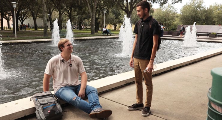 Two USF students talk and enjoy being outside at the MLK Plaza.