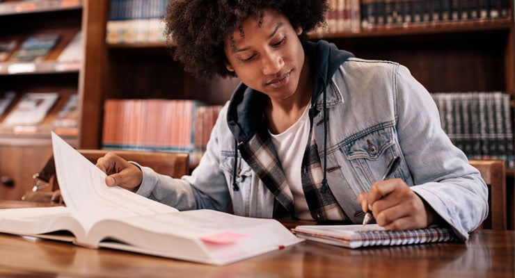 First-generation college student taking notes and studying