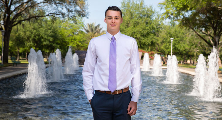Max, one of the USF National Merit Scholars and son of parent Chris, stands outside of the MLK Plaza on the Tampa campus.