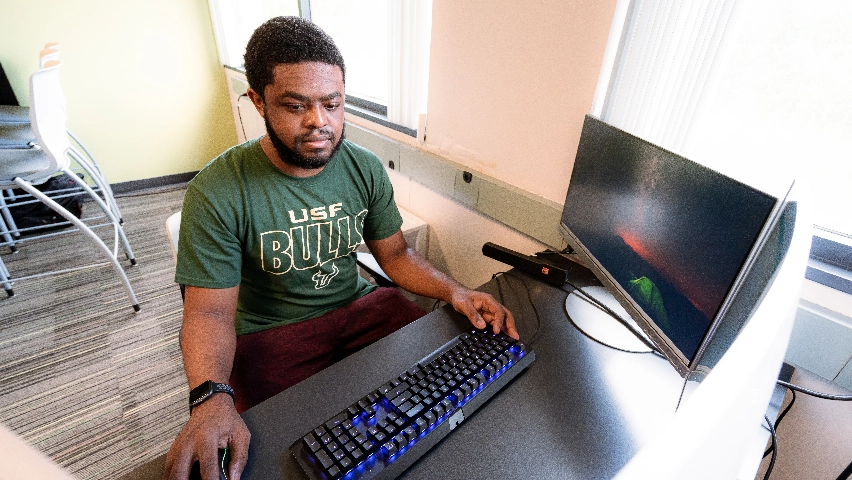 A USF student using a computer.