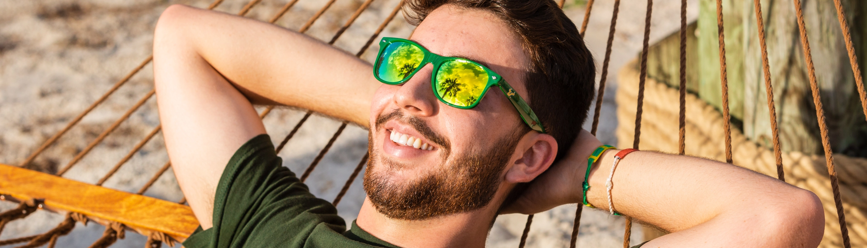 A USF student wearing sunglasses and smiling.