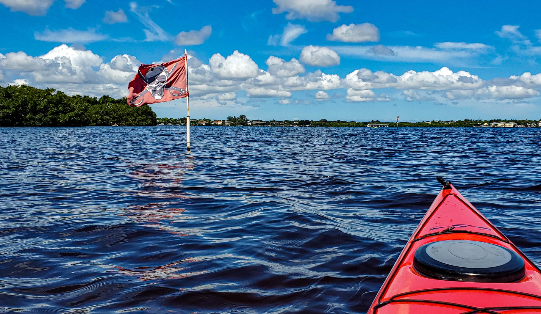 A red pirate flag and a red canoe in the water at Weedon Island.