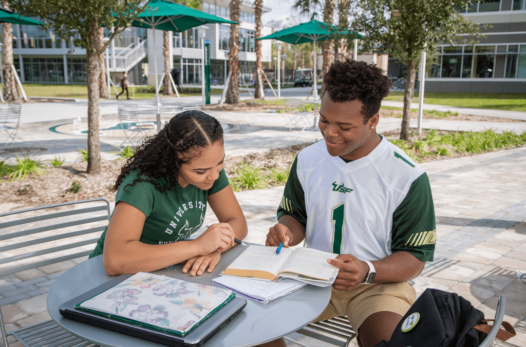 Two USF students studying outdoors.