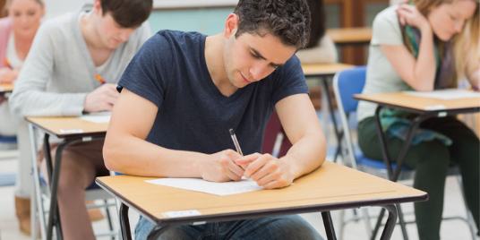 Male student taking his ACT and SAT for college admissions.
