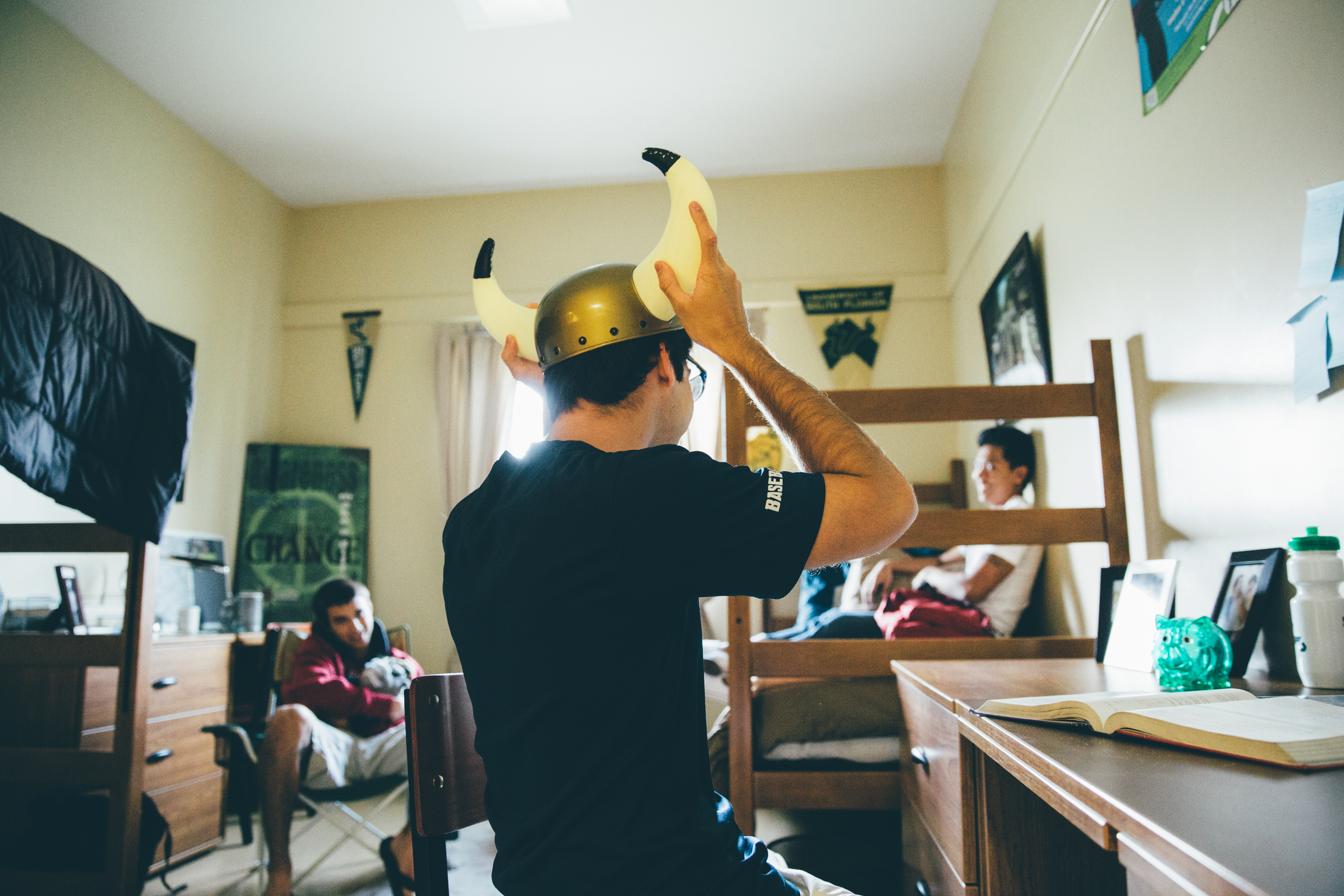 USF student wearing bull horns showing his roommates his bull pride.