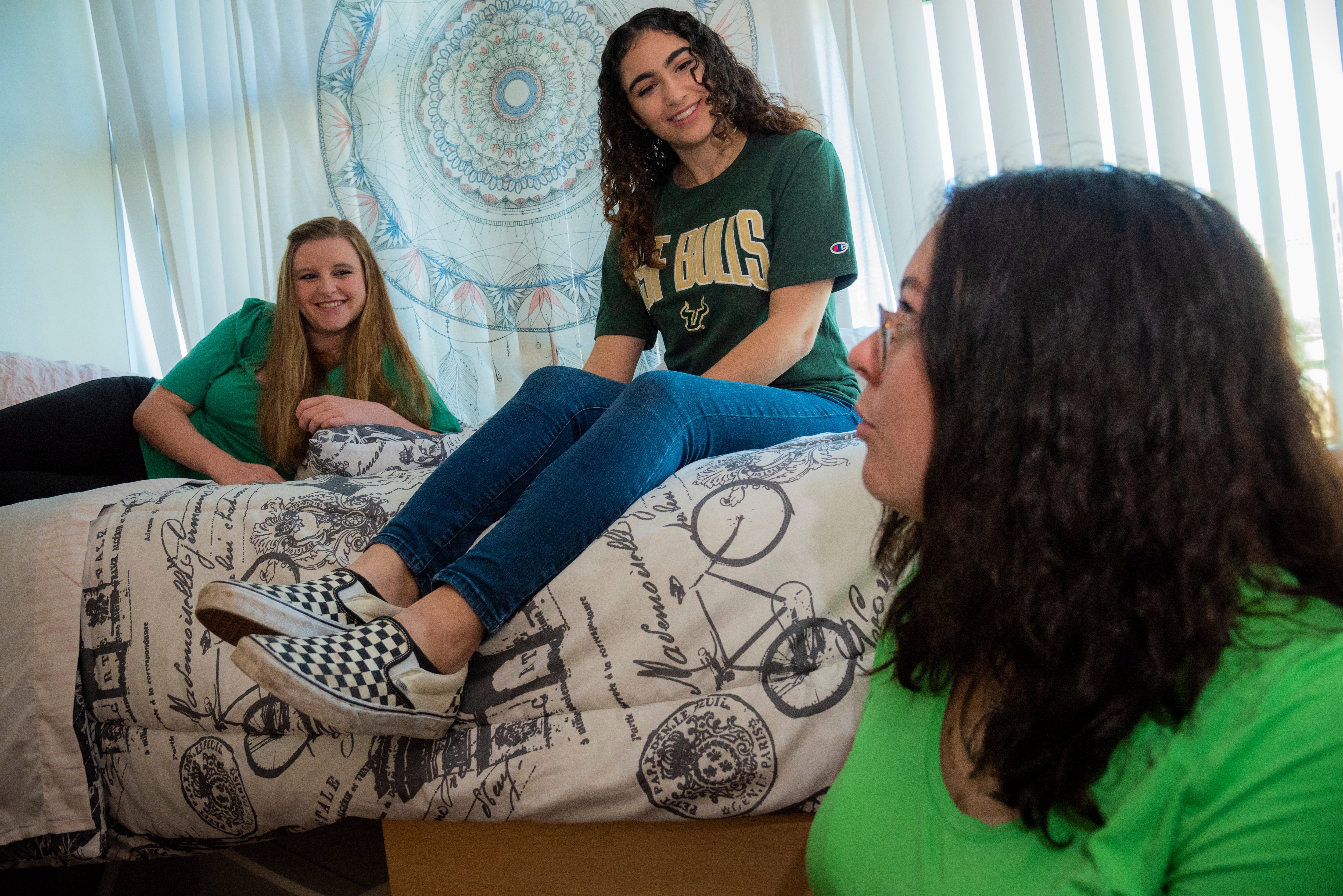 USF students sitting together talking about their new rooms in the dorms.
