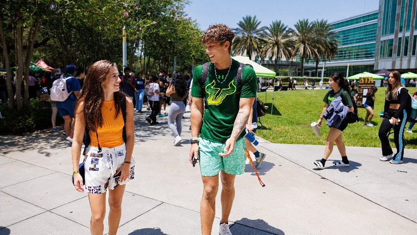 Two USF students walking together on campus during an event.